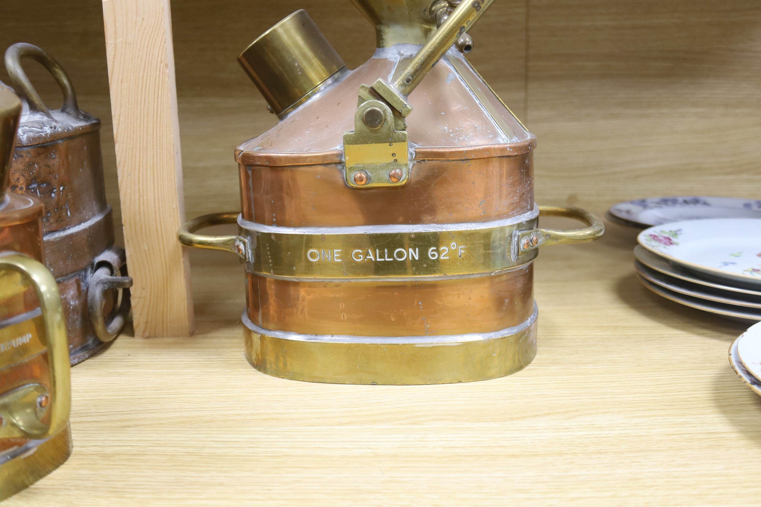 A group of four copper and brass mounted checkpumps, from quart size to one gallon, largest 28cm